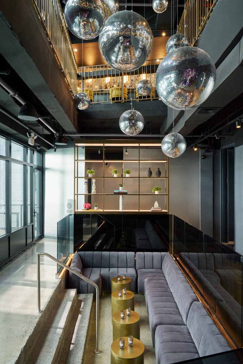 a room with a couch and mirror balls from the ceiling