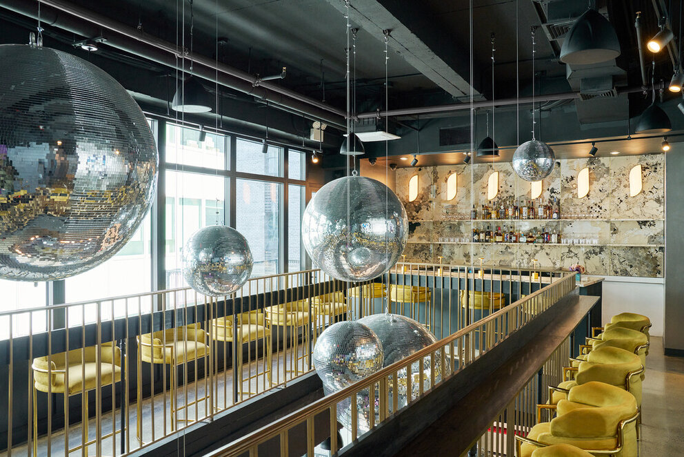 a room with a bar and mirror balls