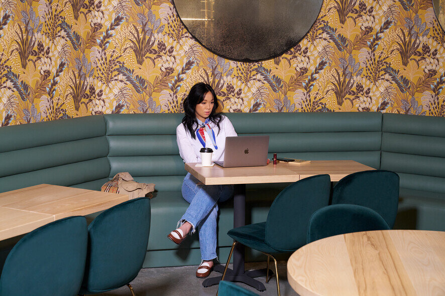 a woman sitting at a table with a laptop