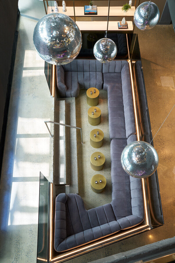 a couch with tables and disco balls from ceiling