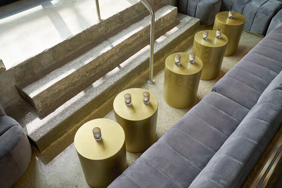 a group of gold tables with a metal railing